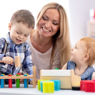 Kindergarten,Teacher,And,Children,Playing,Together,In,Nursery,Or,Daycare