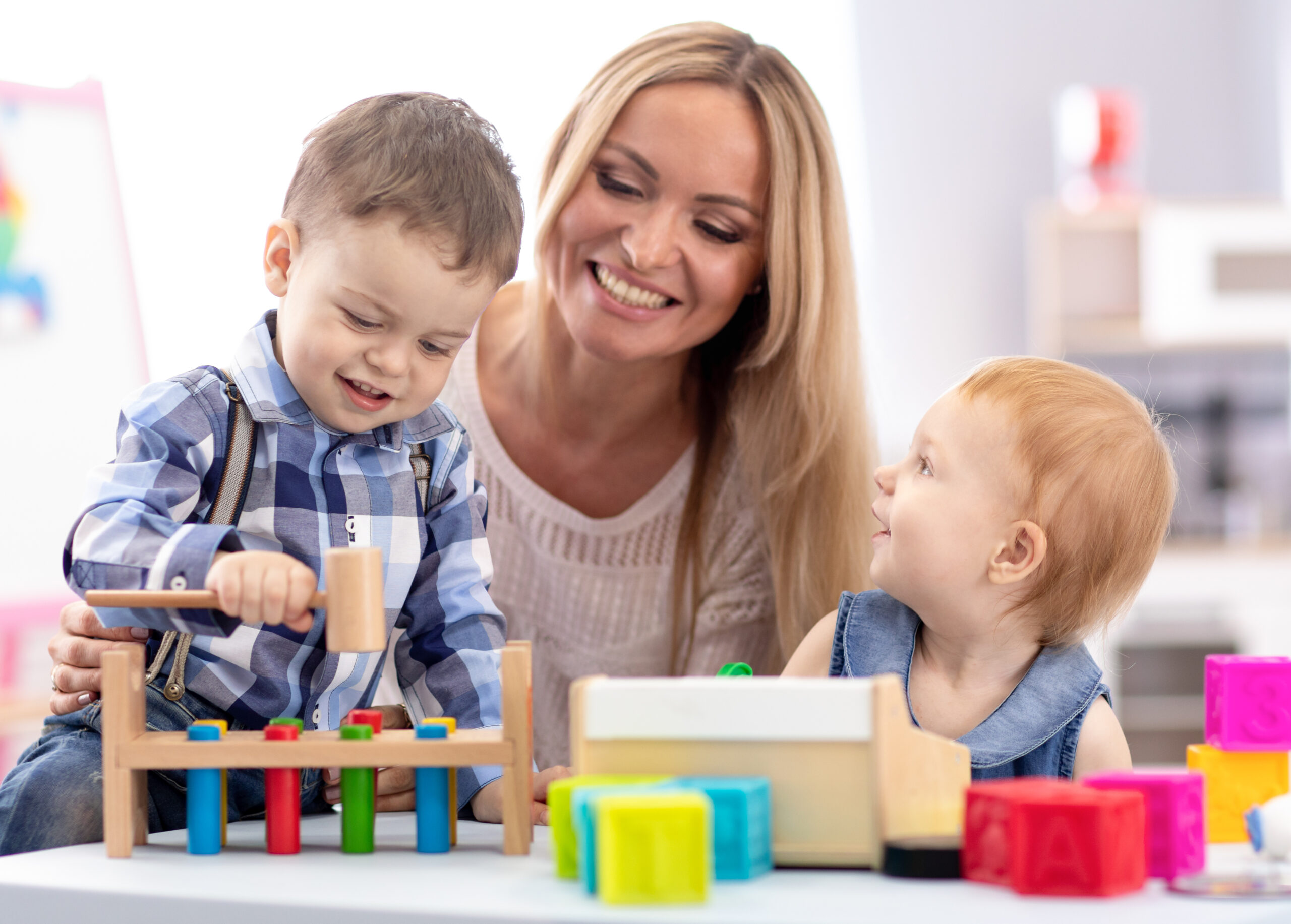 Kindergarten,Teacher,And,Children,Playing,Together,In,Nursery,Or,Daycare